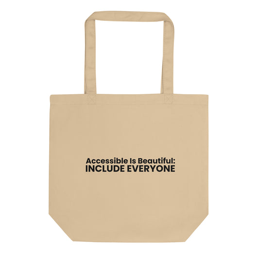 A light beige tote bag with the phrase "Accessible Is Beautiful: INCLUDE EVERYONE" printed on the front. The text is in a bold, black, sans-serif font and is stacked on two lines.