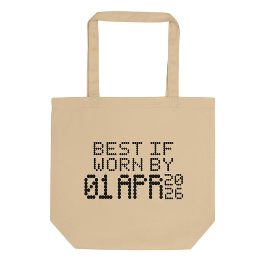 A minimalistic eco tote bag with the phrase “Best If Worn By 01 April 2026” printed in a bold, dot-matrix-style font. The design resembles an expiration date label, blending humor with clean, modern aesthetics.
