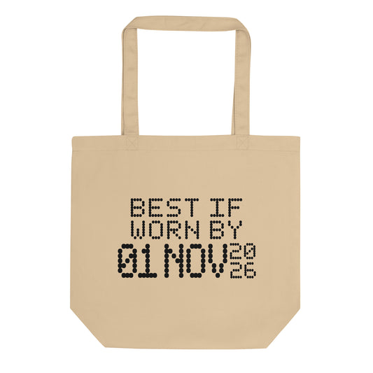 A minimalistic eco tote bag with the phrase “Best If Worn By 01 November 2026” printed in a bold, dot-matrix-style font. The design resembles an expiration date label, blending humor with clean, modern aesthetics.