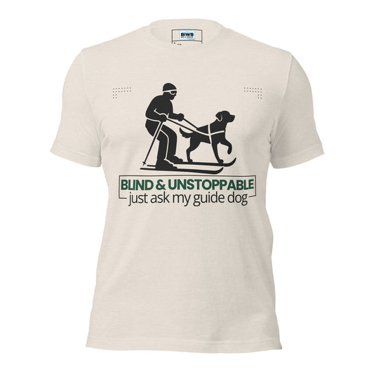 A bold, centered design features a black silhouette of a skier being guided by a harnessed dog, both in forward motion. Below the image, the phrase “BLIND &amp; UNSTOPPABLE – just ask my guide dog” appears in a mix of bold green sans-serif and regular black text. Framing lines and dotted corner accents convey momentum, partnership, and quiet determination.