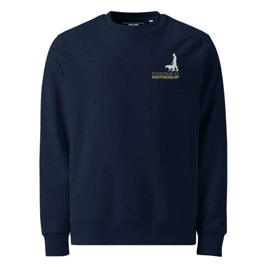 A centered silhouette of a person walking with a guide dog appears above the phrase “POWERED BY PARTNERSHIP.” The top line uses light gray sans-serif text with a paw print inside the letter “D,” while the bottom line is bold gold. The clean layout highlights trust, movement, and the strength of human-canine collaboration.