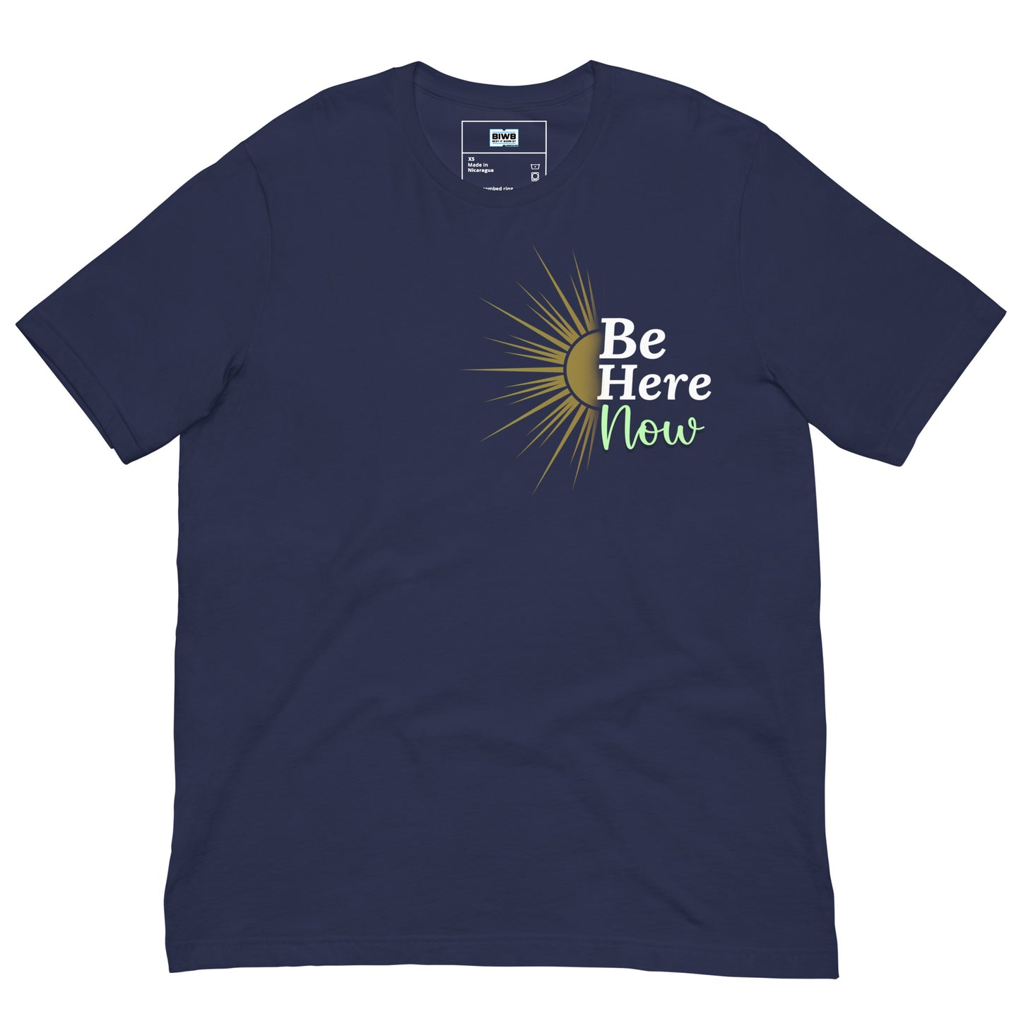 A stylized yellow sun with bold rays radiating outward on the left side, next to the phrase “Be Here Now.” The words “Be” and “Here” are in bold white font, while “Now” is written in soft green script. A thin vertical line divides the sun and text.