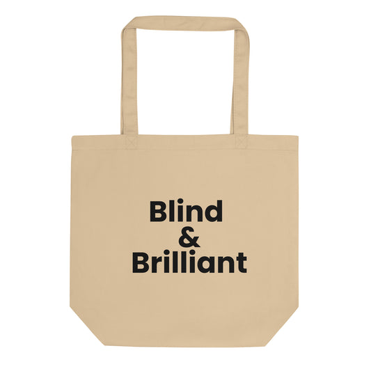 A light beige tote bag with the phrase "Blind &amp; Brilliant" printed on the front. The text is in a bold, black, sans-serif font and is stacked on three lines.