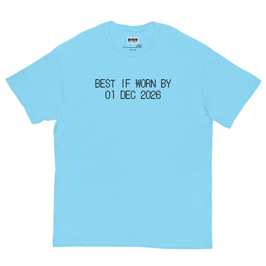 “BEST IF WORN BY 01 DEC 2026” appears in black dot matrix font, styled like a product expiration tag. The design is peaceful, clean, and thought-provoking.