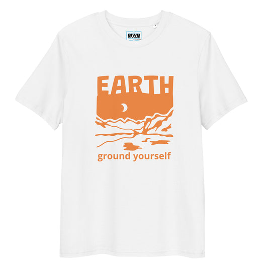 Slate blue t-shirt featuring the word "EARTH" in bold uppercase orange text above a stylized orange illustration of mountains, a crescent moon, and flowing water. Below the artwork, the phrase "ground yourself" appears in lowercase orange letters. Made from 100% organic ring-spun cotton, this unisex t-shirt is a total must-have. It's high-quality